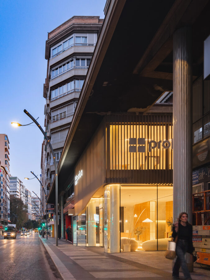 Acceso lateral del showroom Profusa con voladizo y estructura de lamas verticales metálicas