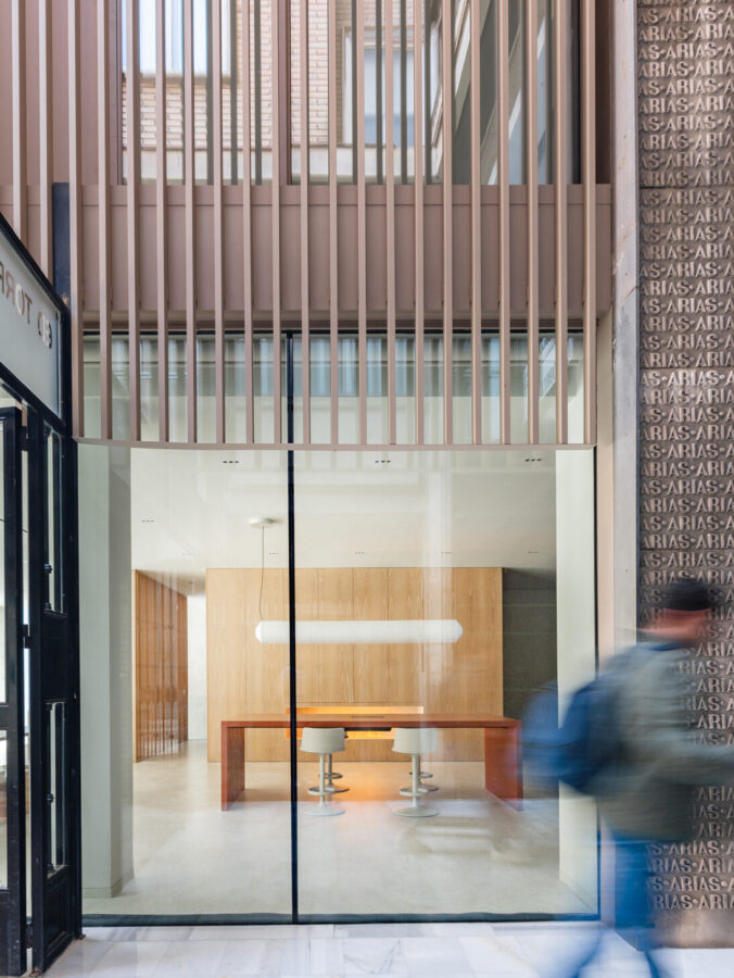 Acceso posterior del showroom Profusa con interior de madera clara y gran mesa de atención