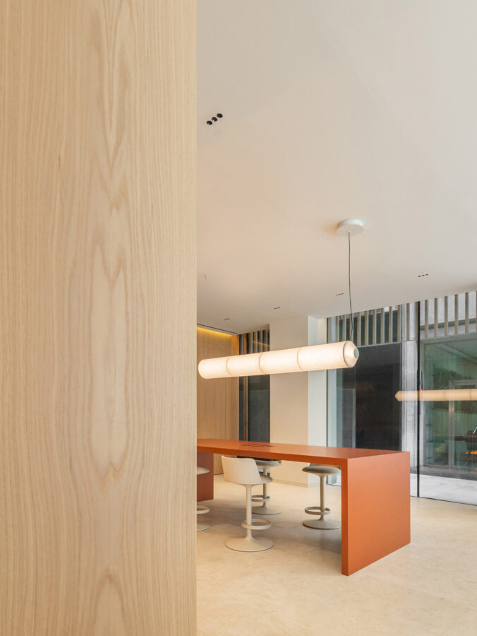 Vista parcial del showroom Profusa con columna de madera y mesa roja al fondo